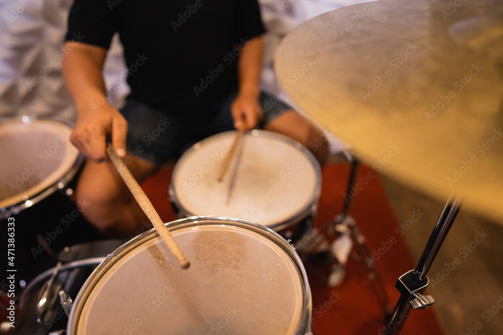 close up of a drummer with drumsticks beating tom-toms and snare drums close up of a drummer with drumsticks beating tom-toms and snare drums