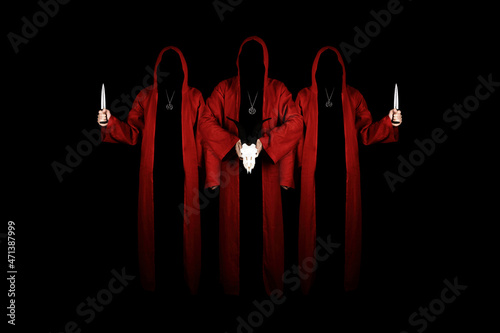 Tablou pe pânză Mystery people in a red hooded cloaks in the dark holding ritual daggers and goat skull
