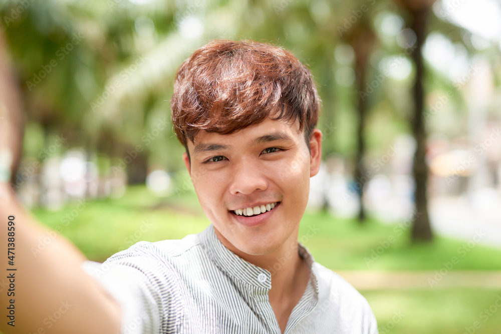 Portrait of a handsome young man taking a selfie with vintage camera Portrait of a handsome young man taking a selfie with vintage camera