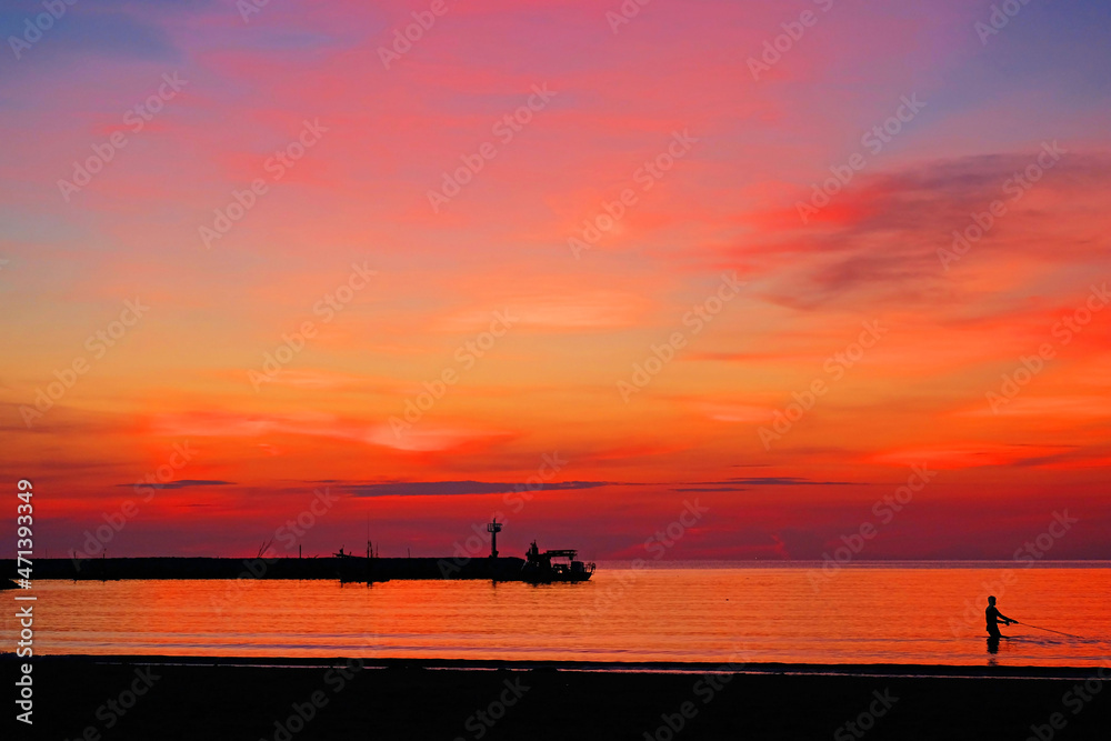 Crimson lights covering the sky and the sea in early morning before sunrise at Hua Hin beach, Thailand 3