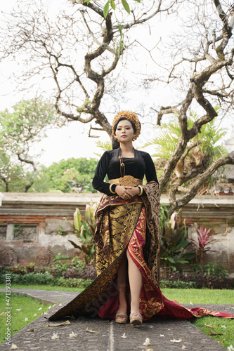 woman wearing Balinese kebaya with trees in the background