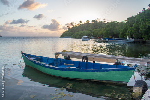 Green and blue canoe docked in a wooden dock in Providencia Island in Colombia