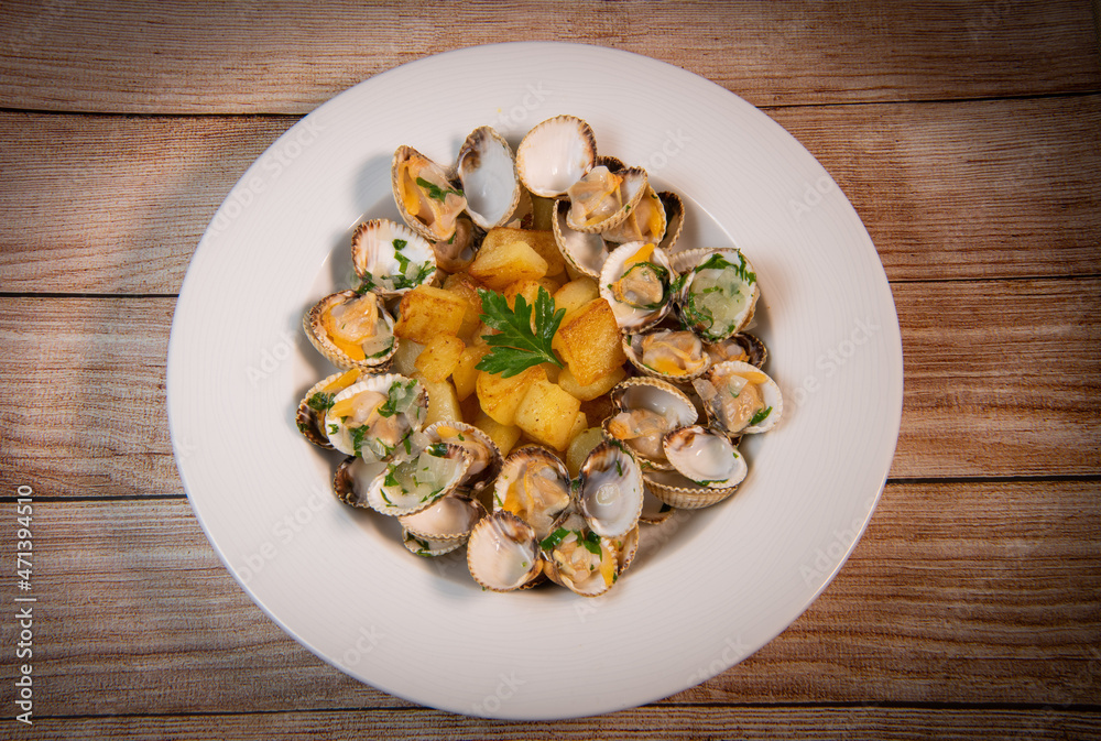 Steamed cockles with fried potatoes in the white dish, mariniere recipe Steamed cockles with fried potatoes in the white dish, mariniere recipe