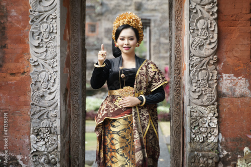 Woman wearing traditional Balinese dress with thumbs up
