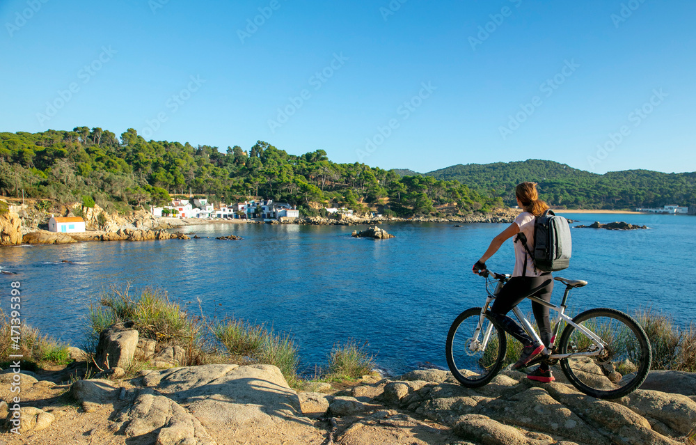 active woman biking along mediterranean sea- costa brava
