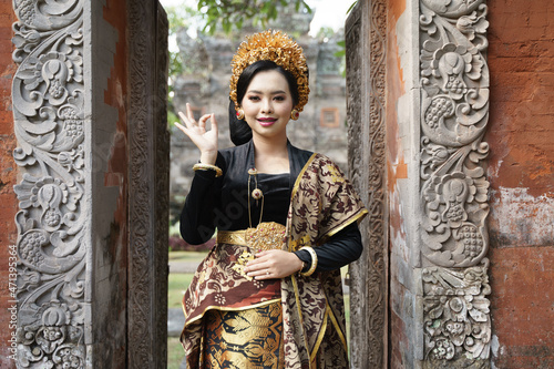Woman wearing traditional Balinese dress with okay gesture photo