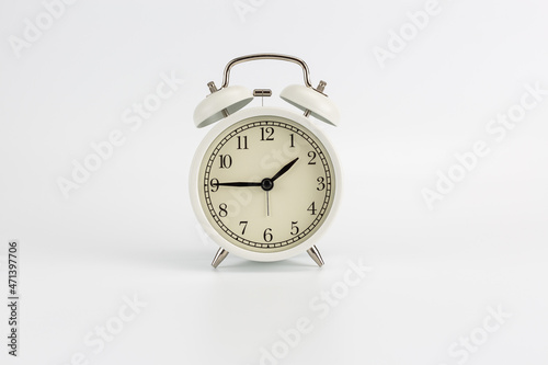 White retro clock alarm clock on white background shows 01:45 am or 01:45 pm or 13:45