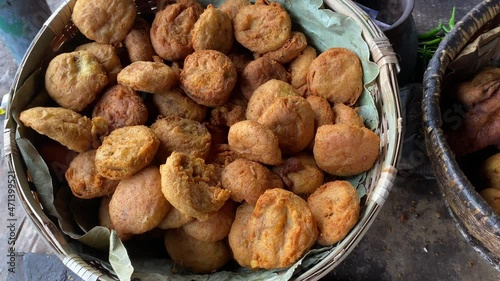 Various fast foods like Piiyaji, gulgula, bara, aloo chop, mangso chop, etc, are being sold by cart puller called thelawalla , are displayed for sale. Image of street foods of Kolkata, West Bengal. photo