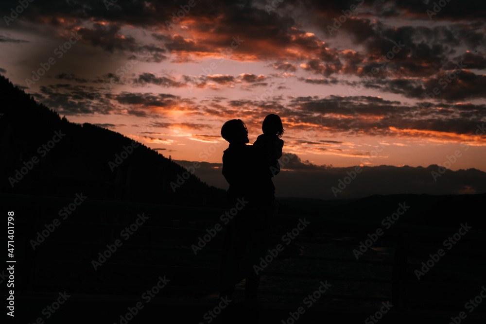 Silhouette of father and daughter in the sunset