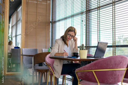 Businesswoman using a laptop while sitting in a cafe during a day