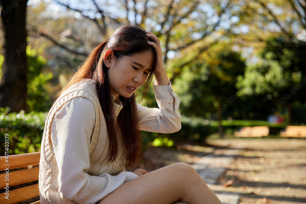 Naklejka premium 公園のベンチで体調不良になる日本人女性