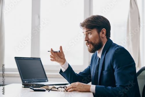 man in a suit in the office in front of a laptop executive success