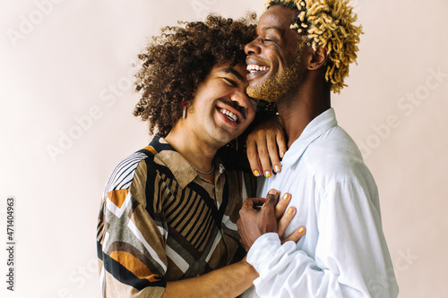 Cheerful gay couple embracing each other in a studio photo