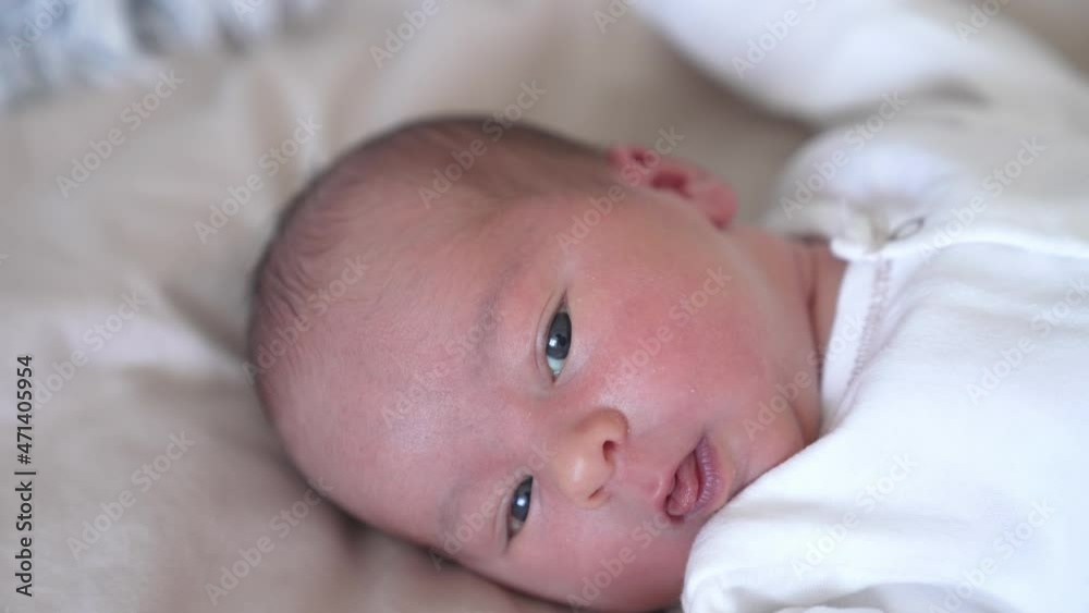 Face of adorable newborn baby. Portrait of healthy cute infant child boy on the bed at home. Happy family relationship and newborn baby. Close-up Face of adorable newborn baby. Portrait of healthy cute infant child boy on the bed at home. Happy family relationship and newborn baby. Close-up