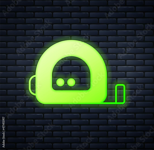Glowing neon Roulette construction icon isolated on brick wall background. Tape measure symbol. Vector