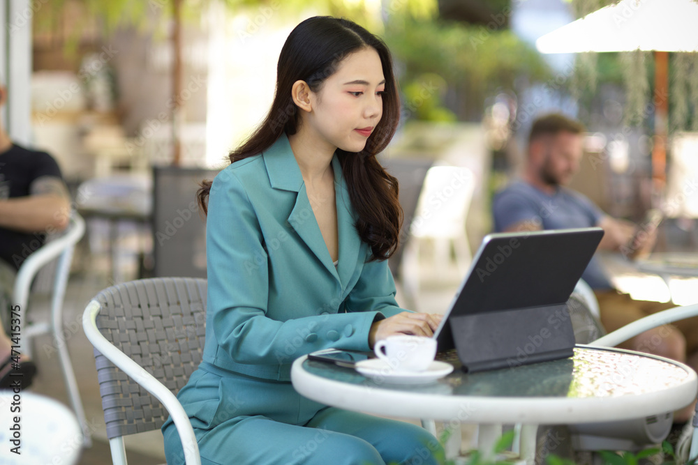 Businesswoman working on tablet computer outside at coffee shop. Businesswoman working on tablet computer outside at coffee shop.
