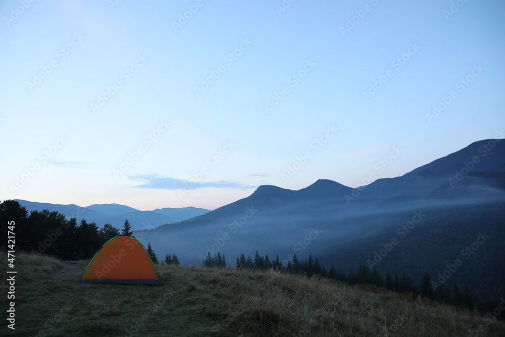 Camping tent on mountain slope in morning