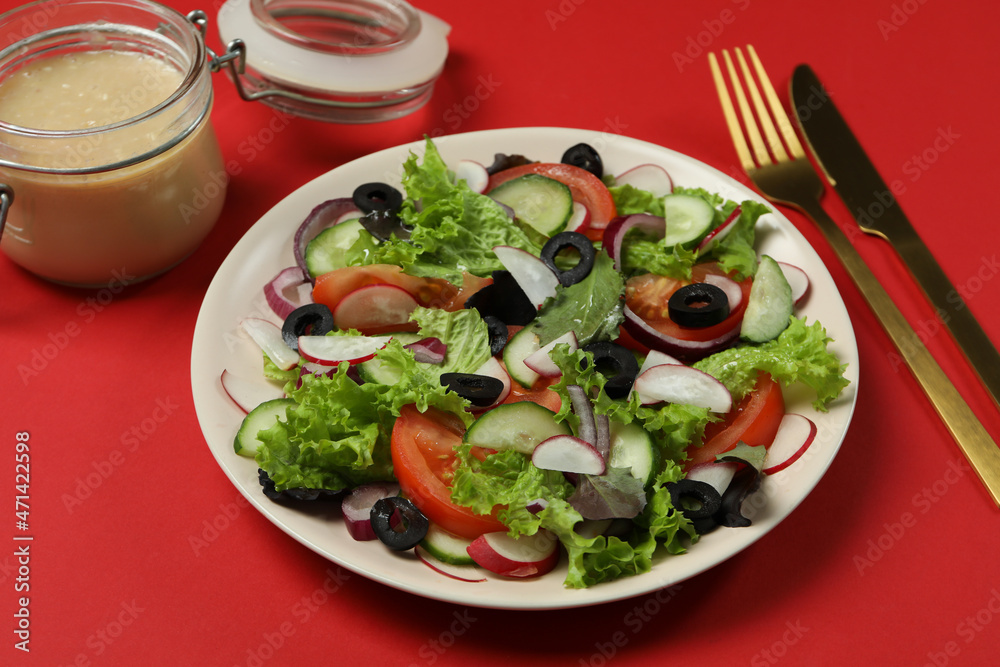 Concept of tasty food with vegetable salad with tahini sauce on red background Concept of tasty food with vegetable salad with tahini sauce on red background