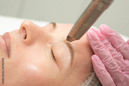 Konstfotografi close-up Doctor cosmetologist makes the procedure of laser dermal rejuvenation of the eyelids of the skin around the eyes to the patient