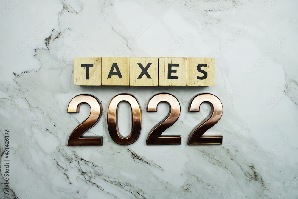 Taxes 2022 alphabet letter on marble background Taxes 2022 alphabet letter on marble background