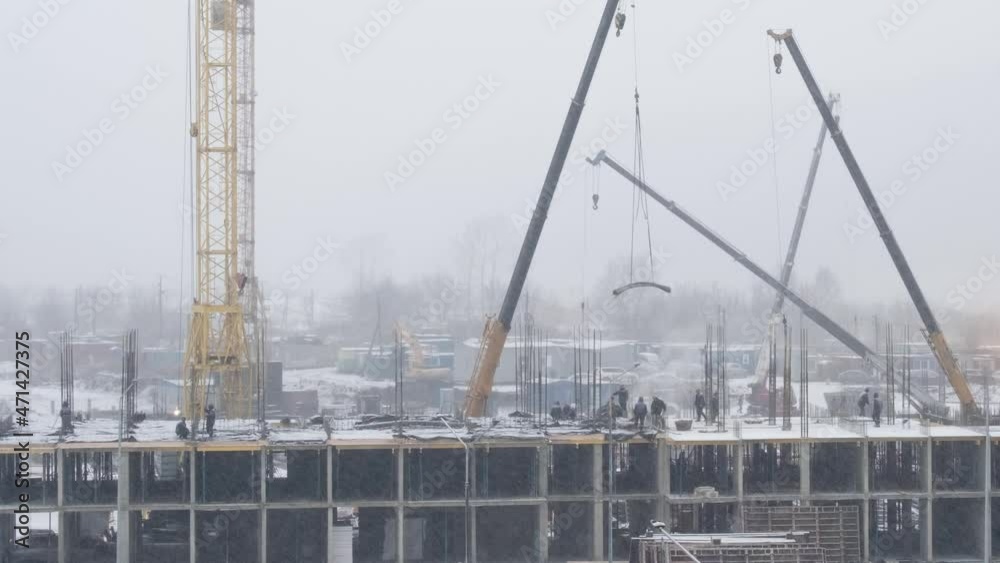 video time-lapse construction of a multi-storey building, in winter, snow, fog