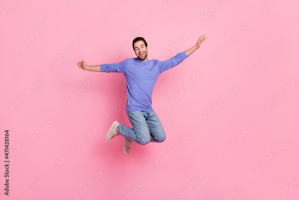 Full size photo of brunet cute young guy jump wear blue pullover jeans footwear isolated on pink background