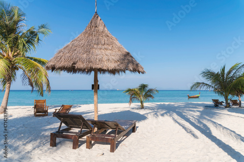 Wooden lounge under thatched umbrella on the beach in tropical sea at Lipe island