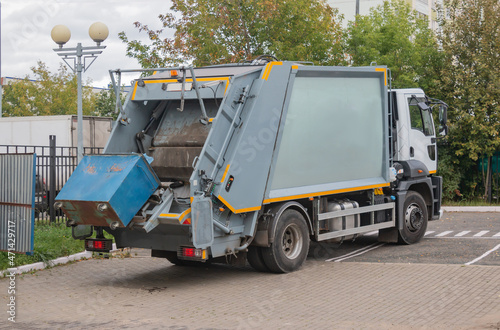 Garbage collection service, A garbage collector working on emptying garbage cans for garbage collection with garbage loading on a truck and a garbage can, Recycling concept.