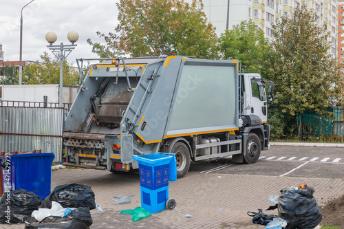 Garbage collection service, A garbage collector working on emptying garbage cans for garbage collection with garbage loading on a truck and a garbage can, Recycling concept.