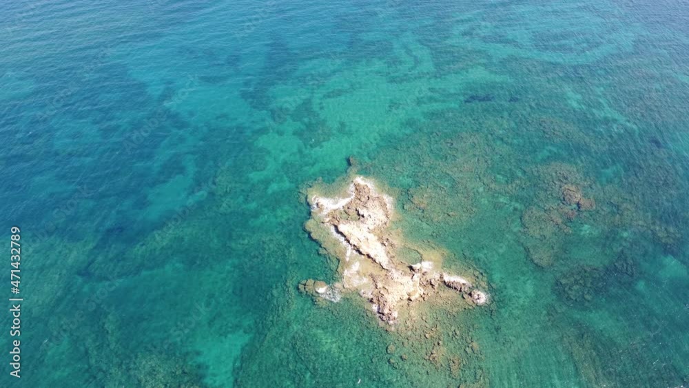 Aerial video view from drone on underwater reefs and coastal rocks in mediterranean sea near beaches with clear transparent water. Camera looks down. Crete, Greece. Aerial video view from drone on underwater reefs and coastal rocks in mediterranean sea near beaches with clear transparent water. Camera looks down. Crete, Greece.
