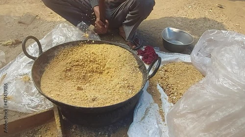 Man Hammering Sesame seeds Til Gul Mixed With Cashew Nut Kaju, Almond Badam, Peanut Moongfali To Make Fine Powder. Ingredient For Khasta Gur Ke Gajak Burfi Or Gazak Laddu On Makar Sankranti And Lohri photo