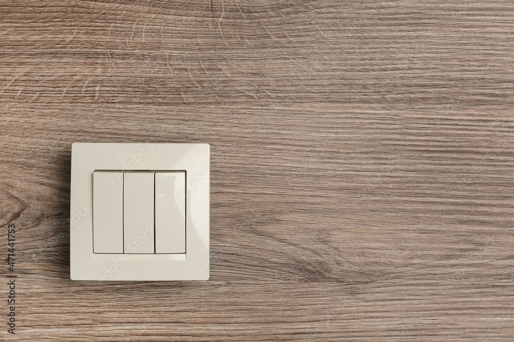 White light switch on wooden background. Space for text White light switch on wooden background. Space for text
