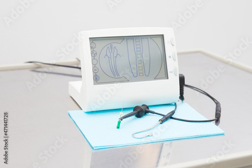 electronic device for the treatment of dental canals in the hands of a dentist in a treatment room. Photo without face