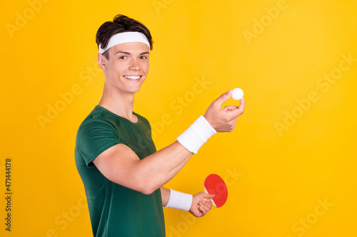 Photo of young cheerful joyful man hold hands ball tennis racket game isolated on yellow color background © deagreez
