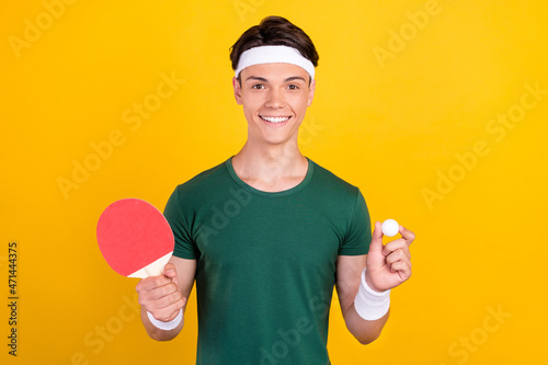 Photo of young charming cheerful man hold hands ball tennis player racket smile isolated on yellow color background © deagreez
