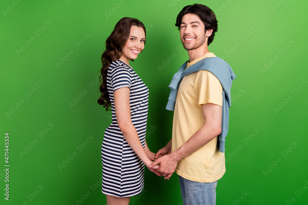 Profile side photo of young couple happy positive smile love feelings romantic isolated over green color background Profile side photo of young couple happy positive smile love feelings romantic isolated over green color background
