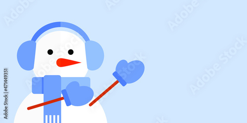 Snowman in blue headphones, scarf and mittens on a blue background points to the empty space on the side