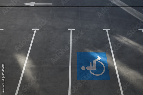 Car parking lot with white marking lines and wheelchair symbol outdoors, above view
