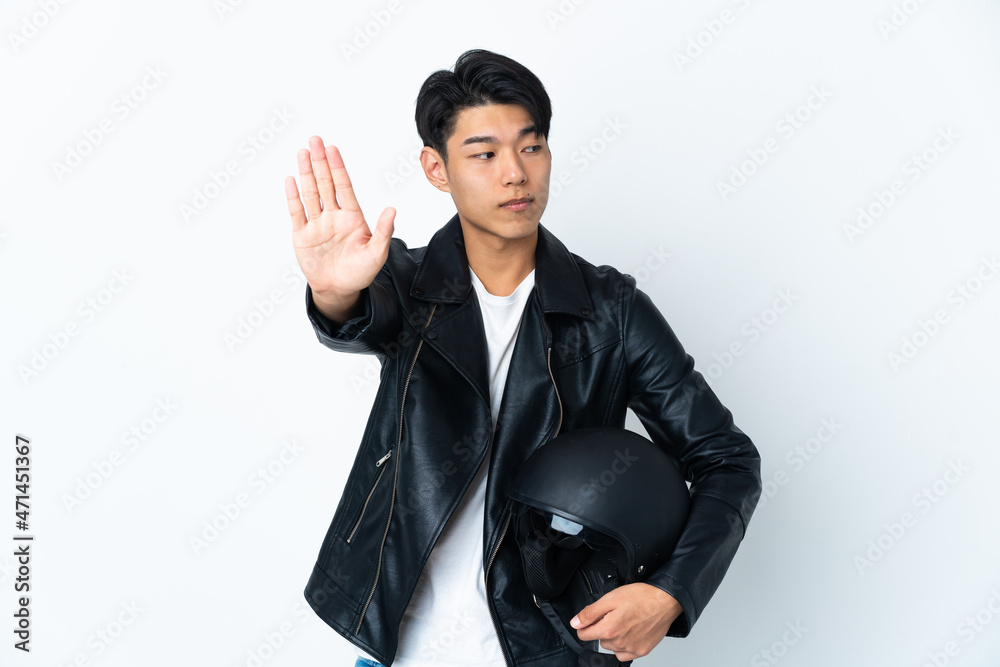 Chinese man with a motorcycle helmet isolated on white background making stop gesture and disappointed Chinese man with a motorcycle helmet isolated on white background making stop gesture and disappointed
