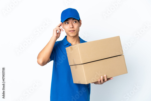 Delivery Chinese man isolated on white background having doubts and thinking