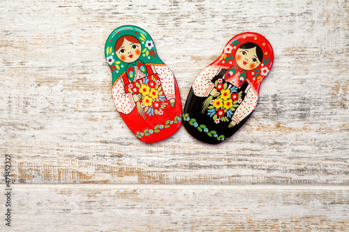 Girl, matreshka, woman in Russian national sundress and a kokoshnik with bouquet of flowers in hand on wooden background