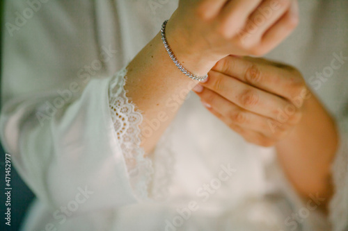 Female woman touch shiny stylish bracelet on right hand close up. Bridal accessories on wedding day