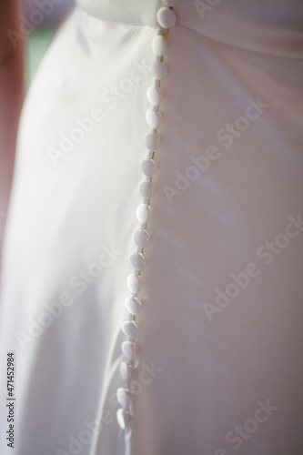 Wedding dress buttons on back side closed glowing background .Wedding dress styles and preparation concept