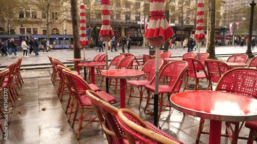 Paris wet  red tables poured by raindrops empty closed outdoors restaurant court in city center Champs Elysees  photo
