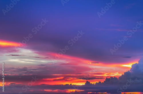 The sun shines through the clouds in the sunset sky with dramatic light. The shape of the clouds.