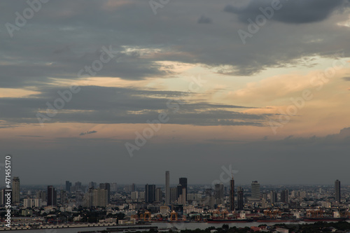 Bangkok, Thailand - Sep 12, 2021 : Gorgeous panorama scenic of the sunrise or sunset with cloud on the orange and blue sky over large metropolitan city in Bangkok. Copy space, No focus, specifically. © num