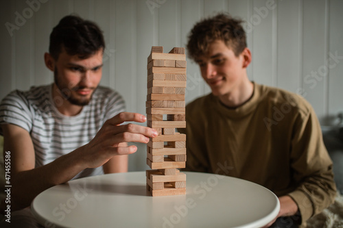 The hands of business men playing a game with wooden blocks. Conceptual risk management and strategic plans for business growth and success. 2 businessmen play a game with wooden blocks