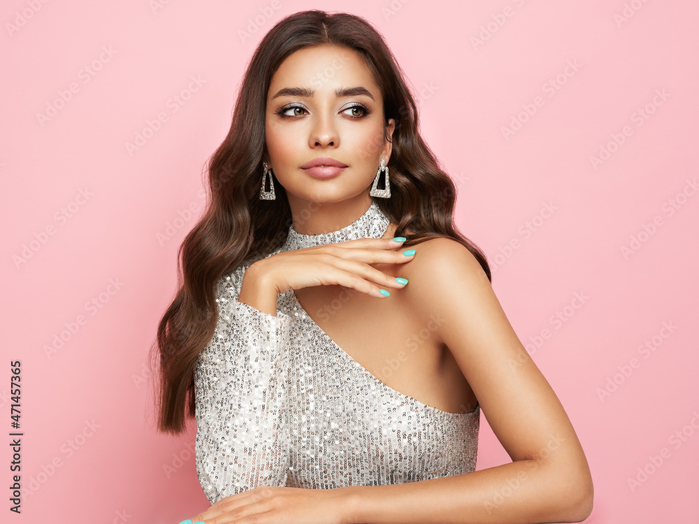 Beautiful woman in cocktail dress posing on pink background. Beauty model  with long curly hair. Christmas or New Year festivities. Jewelry and  manicure Photos | Adobe Stock
