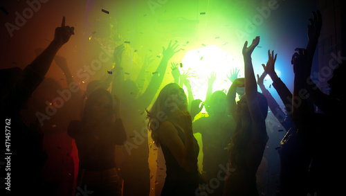 Photo of cheerful bachelorette clubbers buddies enjoy nightlife show air hands up show dancing on disco floor with neon filter lights