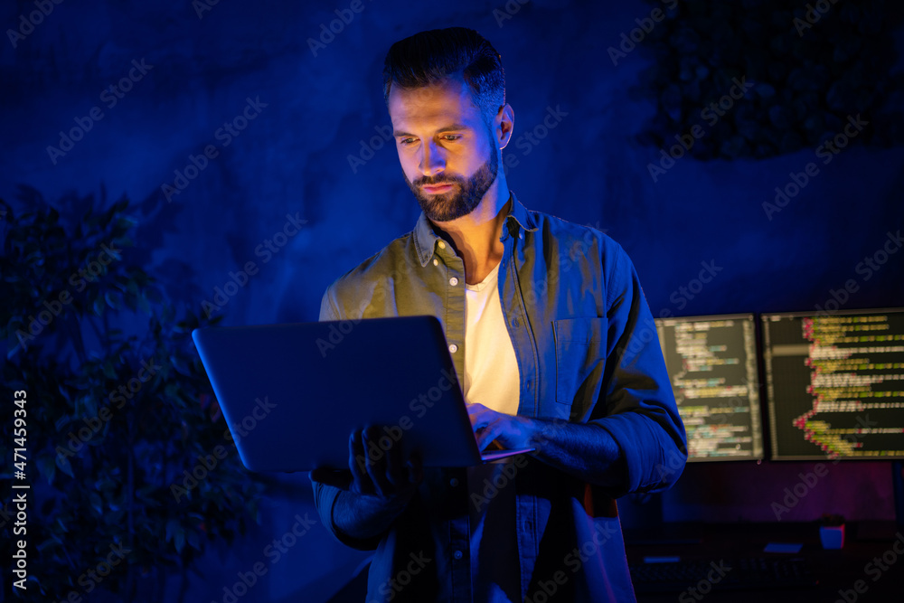 Photo of calm focused smart person hold netbook write email research information dark office room Photo of calm focused smart person hold netbook write email research information dark office room